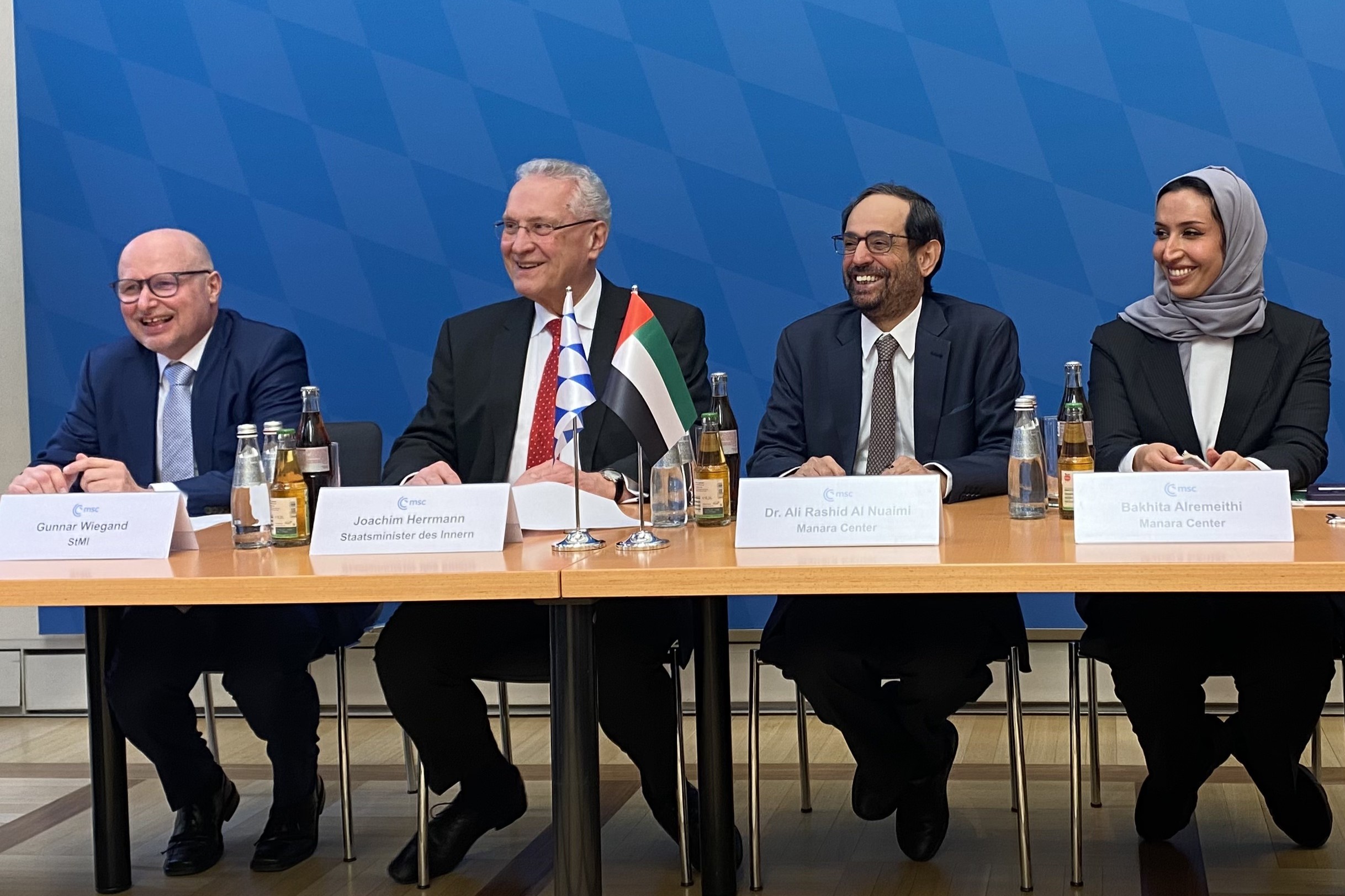 Foto von Gunnar Wiegand (StMi), Joachim Herrmann (Staatsminister des Innern), Dr. Ali Rashid Al Nuaimi (Manara Center) und Bakhita Alremeithi (Manara Center) an Konferenztischen